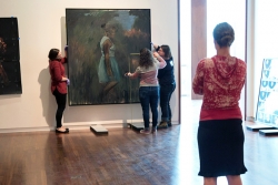 UMFA curator Whitney Tassie (foreground) and collections staff install British artist Lynette Yiadom-Boakye’s Periphery (2013) in the UMFA’s expanded modern and contemporary gallery. 